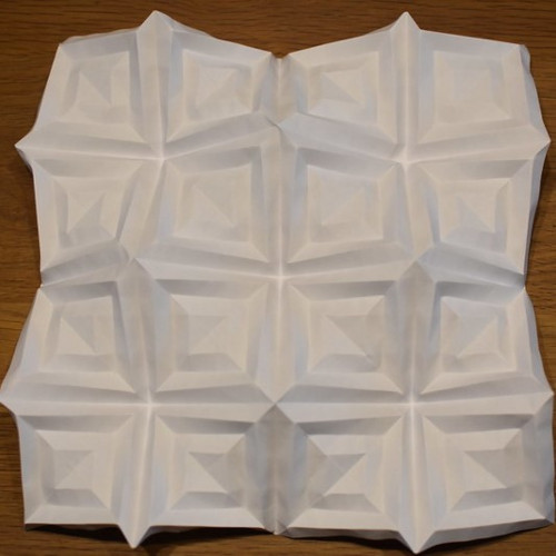 A white folded paper on a wood surface

Description automatically generated