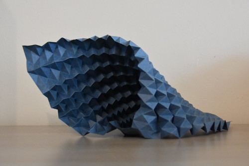 A blue paper sculpture of a fish

Description automatically generated